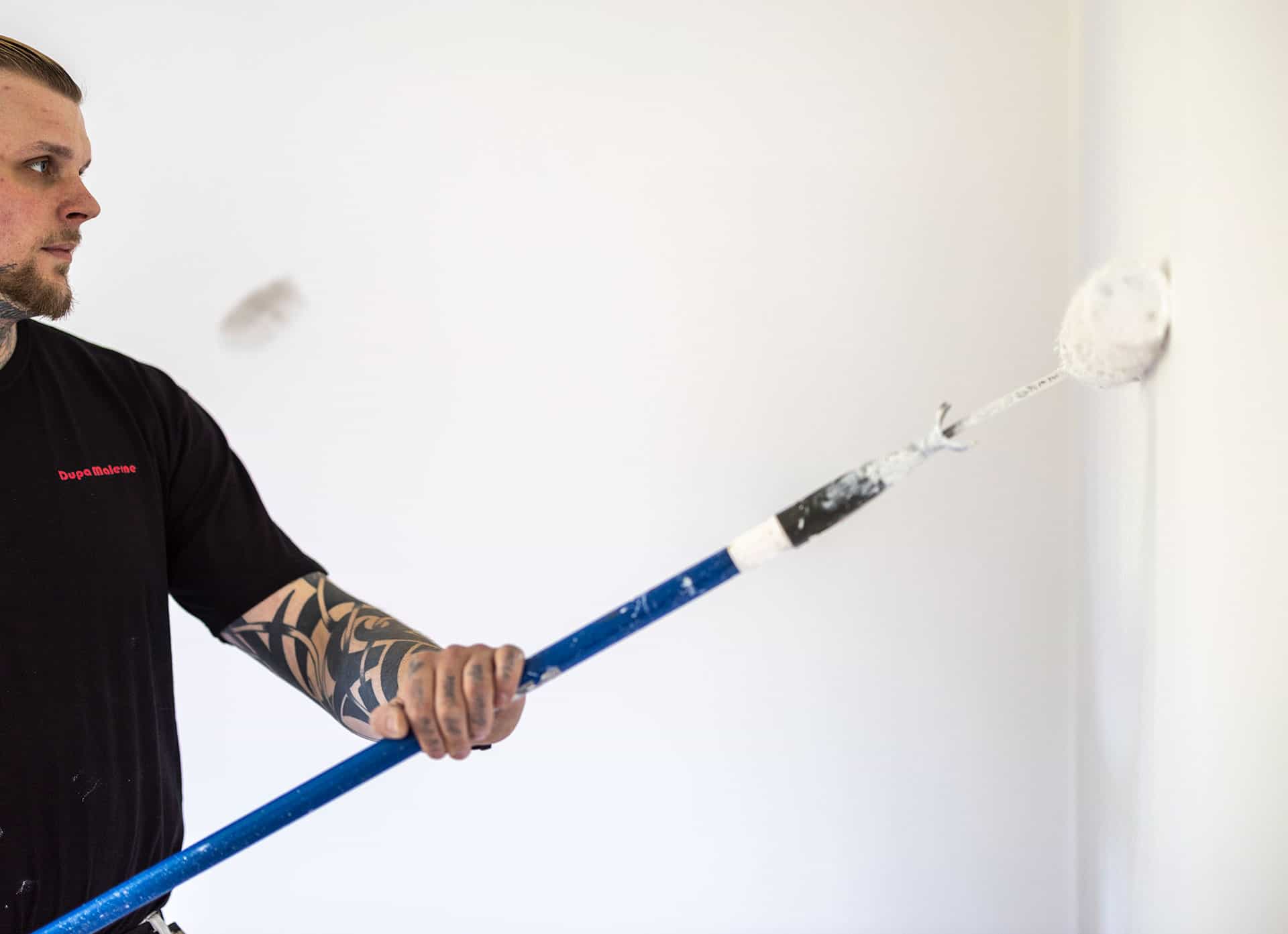 Maler i gang med malerarbejde